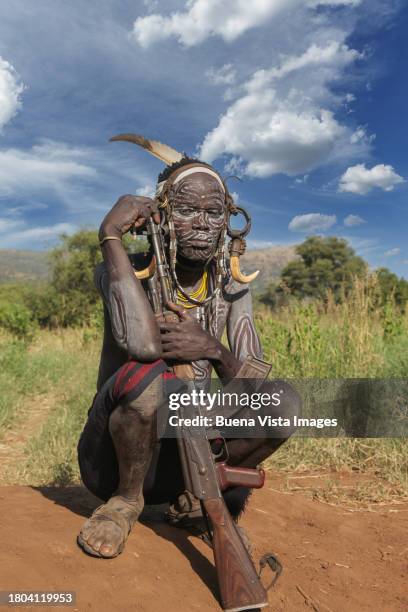 african tribe man with ak-47 rifle. - clay earring stock pictures, royalty-free photos & images