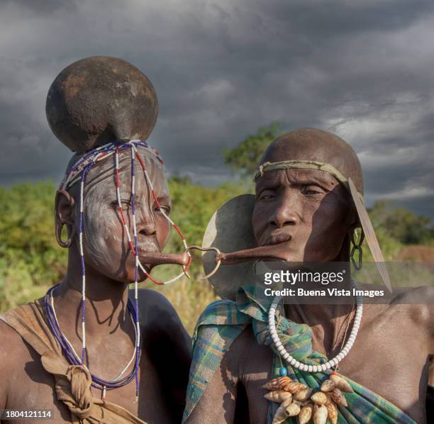 ethiopia. couple of  the mursi tribe joined at the lips by a brass ring - clay earring stock pictures, royalty-free photos & images