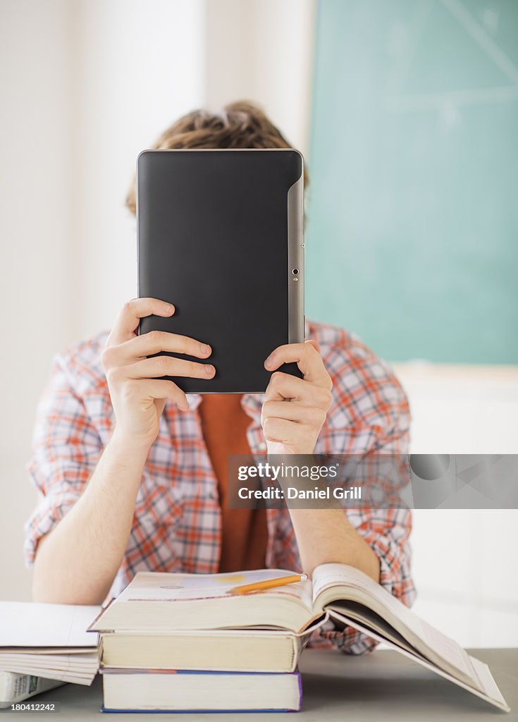 USA, New Jersey, Jersey City, Teenage boy (14-15) sitting in classroom with tablet pc