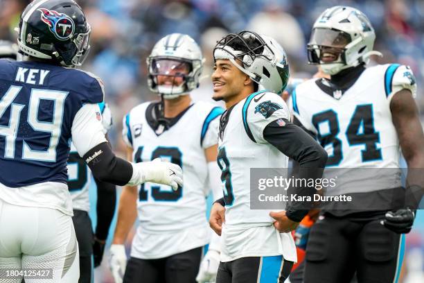 Bryce Young of the Carolina Panthers laughs with Arden Key of the Tennessee Titans during an NFL game at Nissan Stadium on November 26, 2023 in...