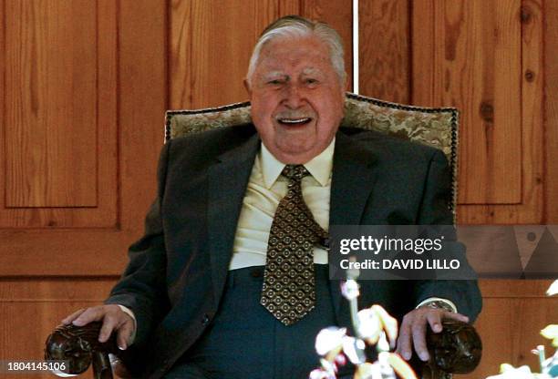 Former Chilean dictator , Augusto Pinochet, smiles as he watches a crowd of supporters who arrived at his residence in the outskirts of Santiago, to...