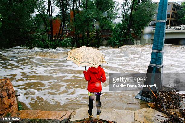 Woman looks at Boulder Creek, which flooded early today after three days of heavy rainfall September 12, 2013 in Boulder, Colorado. An estimated 6-10...