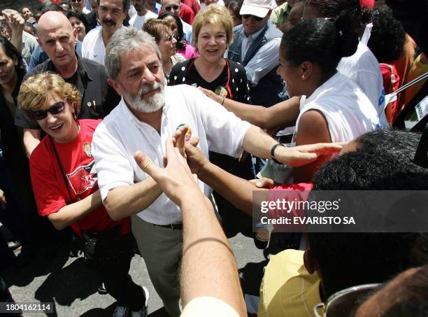 Brazilian President and re-election candidate Luiz Inacio Lula da Silva and his wife Marisa Leticia greet supporters during a campaign rally in Sao...