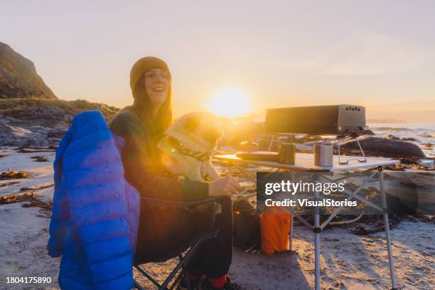 femme heureuse avec son chien contemplant le pique-à la plage en profitant d’un coucher de soleil pittoresque - winter break film 2023 photos et images de collection
