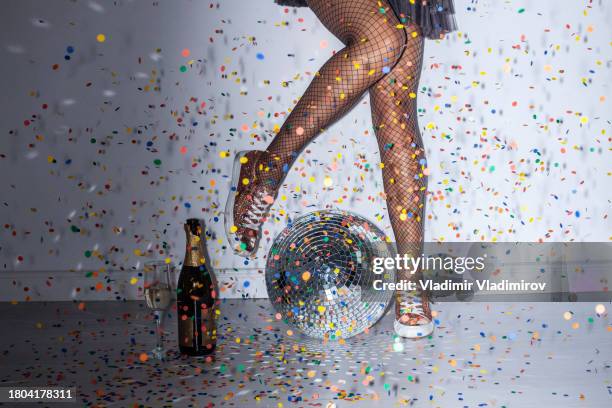 legs celebrating in a new year party under shower of confetti - under skirt stock pictures, royalty-free photos & images