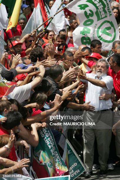 Brazil's President and reelection candidate Luiz Inacio Lula da Silva , of the Workers' Party , greets supporters during a parade in his political...