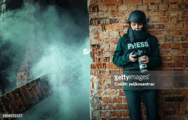 a female photojournalist in a war zone - photojournalist stock pictures, royalty-free photos & images