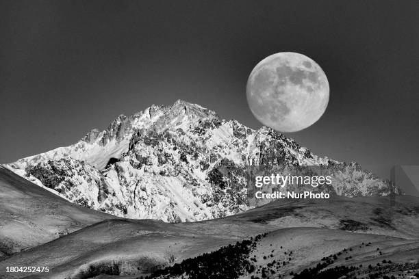 Photo has been converted in black and white colors) Beaver full moon rising above Monte Prena Mountain is seen from L'Aquila, Italy, on November...