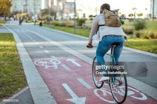 cyclist in city traffic using the bicycle lane - fiets stockfoto's en -beelden