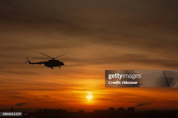 military helicopters flying over the city during a military conflict at sunset - surveillance during a counter-terrorism operation - attack helicopter stock pictures, royalty-free photos & images