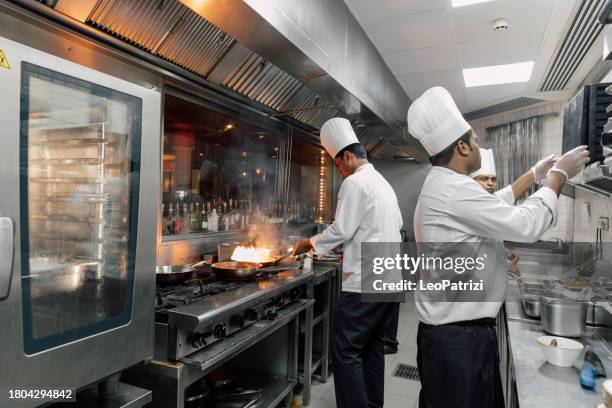 professional chefs in a commercial kitchen of a fine dining restaurant - brigade stock pictures, royalty-free photos & images