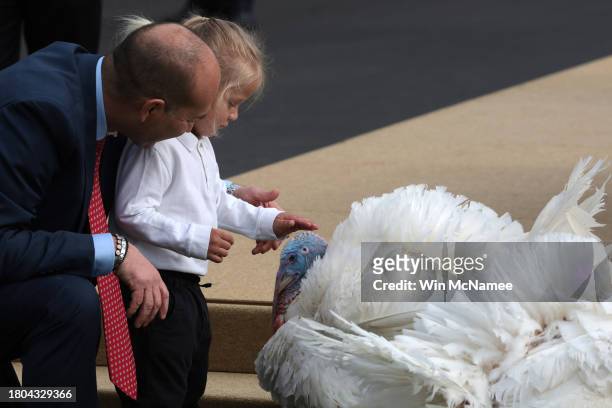 Beau Biden, the grandson of U.S. President Joe Biden, pets Liberty the National Thanksgiving Turkey, during the pardoning ceremony on the South Lawn...