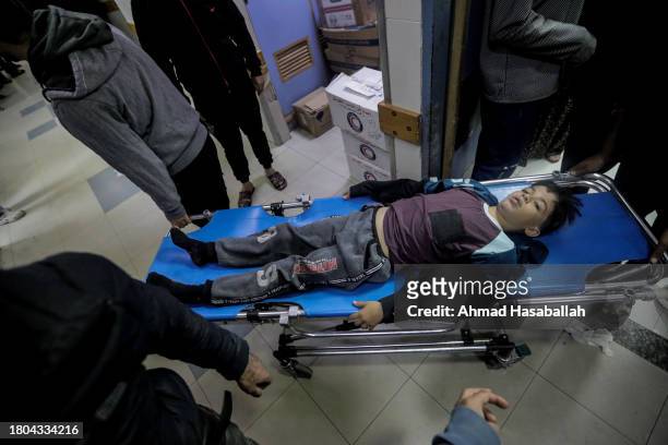 Young boy on a stretcher is transported as Palestinians injured in airstrikes arrive at Nasser Medical Hospital on November 20, 2023 in Khan Yunis,...