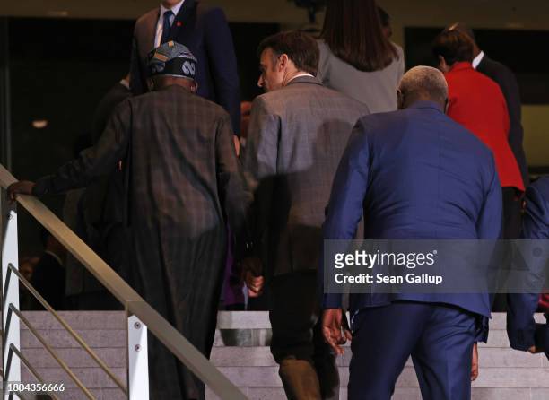 French President Emmanuel Macron holds hands with Bola Ahmed Adekunle Tinubu , President of Nigeria, as they chat and walk up stairs at the G20...
