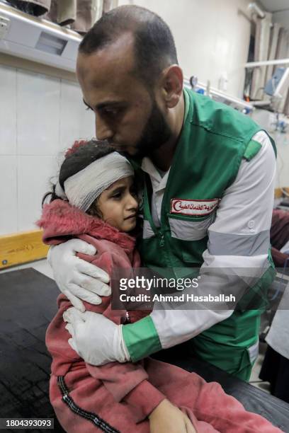Man consoles a young girl as Palestinians injured in airstrikes arrive at Nasser Medical Hospital on November 20, 2023 in Khan Yunis, Gaza. More Gaza...