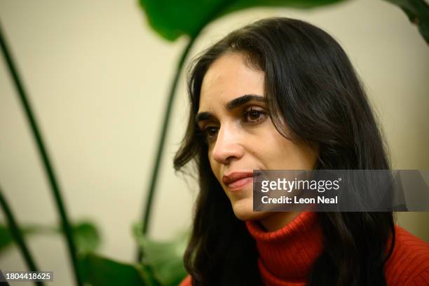 Israeli actress Liraz Charhi listens as family members of those taken hostage by Hamas speak to journalists during a press conference at the Embassy...
