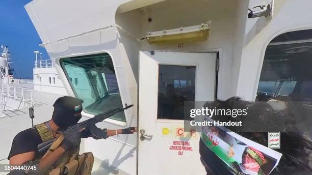 This handout screen grab captured from a video shows Yemen's Houthi fighters' takeover of the Galaxy Leader Cargo in the Red Sea coast off Hudaydah,...