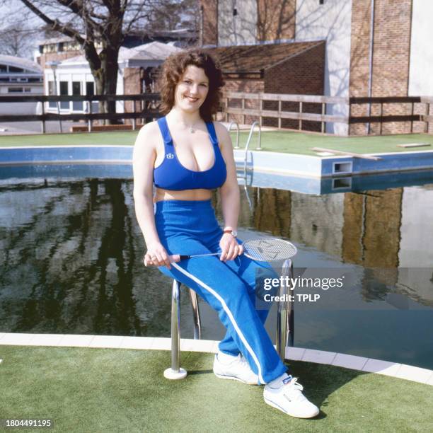 Portrait of British bookstore employee Erika Roe, also known as the Twickenham Streaker, as she poses, beside a swimming pool, with a badminton...