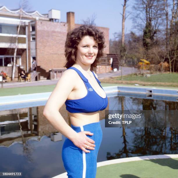 Portrait of British bookstore employee Erika Roe, also known as the Twickenham Streaker, as she poses beside a swimming pool, London, England, March...