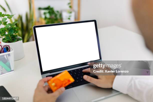 unrecognizable person hands holding plastic credit card and using laptop. - credit card mockup stock-fotos und bilder