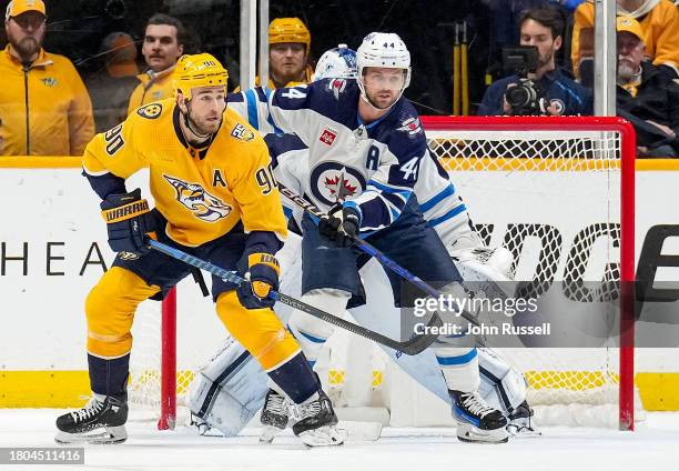 Ryan O'Reilly of the Nashville Predators battles in front of the net against Josh Morrissey of the Winnipeg Jets during an NHL game at Bridgestone...