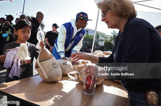 Los Angeles police officer passes out free turkeys during the 3rd annual turkey drive at Wilshire Station on November 20, 2023 in Los Angeles,...