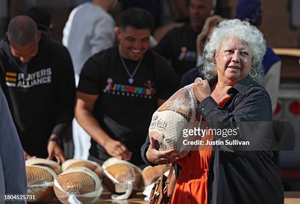 Woman carries a turkey during the 3rd annual turkey drive at Wilshire Station on November 20, 2023 in Los Angeles, California. The Los Angeles Police...