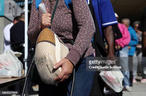 Woman carries away a free turkey during the 3rd annual Los Angeles Police Department turkey drive at Wilshire Station on November 20, 2023 in Los...