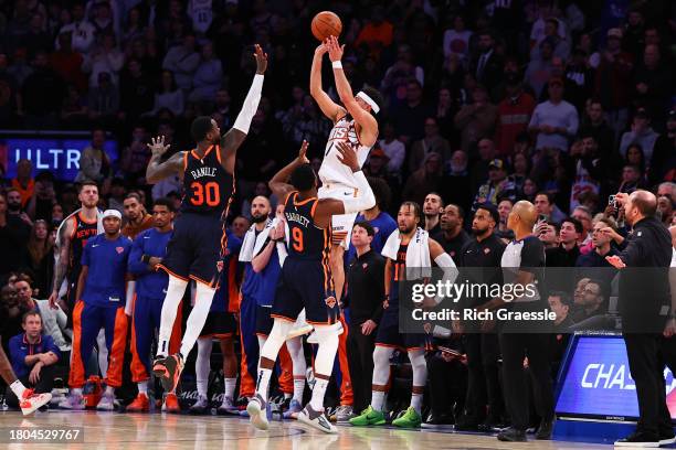 Devin Booker of the Phoenix Suns makes a three-point basket with 1.7 seconds left in the fourth quarter during the game against the New York Knicks...