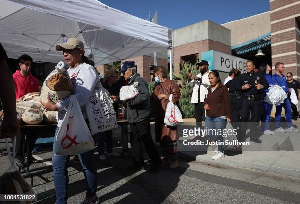 People line up to receive a free turkey during the 3rd annual Los Angeles Police Department turkey drive at Wilshire Station on November 20, 2023 in...