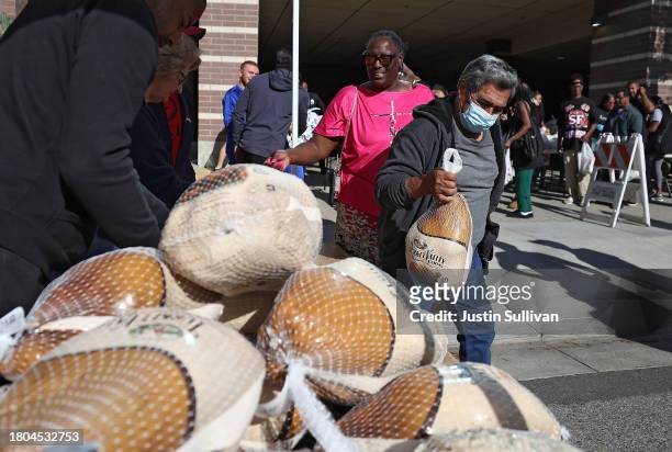 People receive a free turkey during the 3rd annual Los Angeles Police Department turkey drive at Wilshire Station on November 20, 2023 in Los...