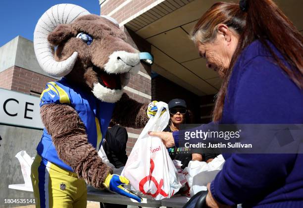 Los Angeles Rams mascot "Rampage" passes out bags of food during the 3rd annual Los Angeles Police Department turkey drive at Wilshire Station on...