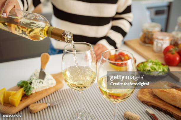 close up of a woman pouring white for dinner - kitchen bench stock pictures, royalty-free photos & images