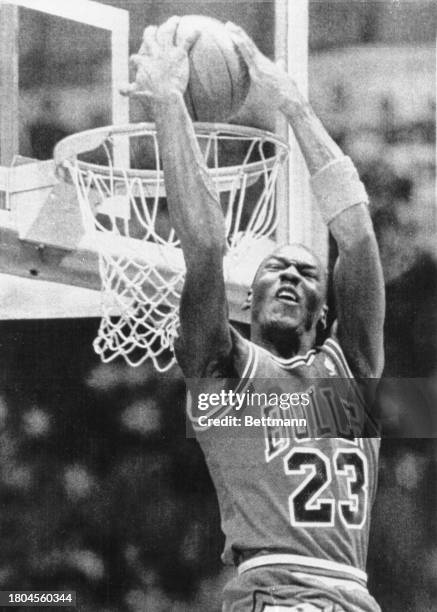 Michael Jordan on the hoop rim in Seattle, Washington, after one of his slam dunks in the NBA Slam Dunk competition.