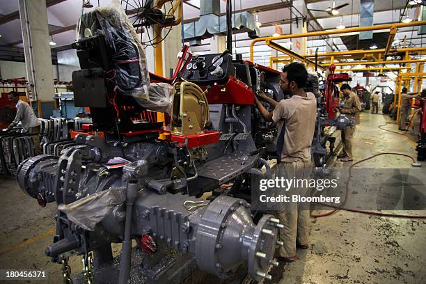 An employee secures tractor body parts on the production line of the Millat Tractors Ltd. Assembly plant in Lahore, Pakistan, on Thursday, Aug. 29,...