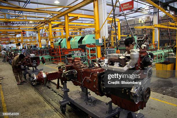 Employees work on engines on the production line of the Millat Tractors Ltd. Assembly plant in Lahore, Pakistan, on Thursday, Aug. 29, 2013. Millat...