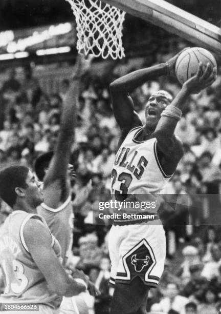 Chicago Bulls guard, Michael Jordan, goes up for a basket against the Cleveland Cavaliers' center, Brad Daugherty and forward John Williams in the...