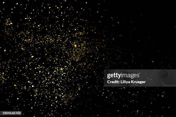 gold glitter isolated on a black background. - gold and black background stock pictures, royalty-free photos & images