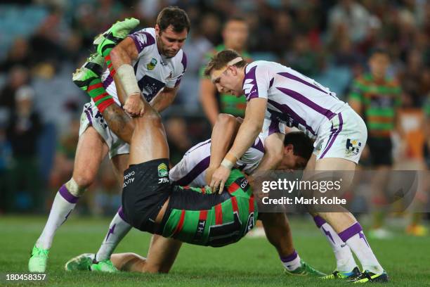 Roy Asotasi of the Rabbitohs is picked up as he is tackled during the NRL Qualifying match between the South Sydney Rabbitohs and the Melbourne Storm...