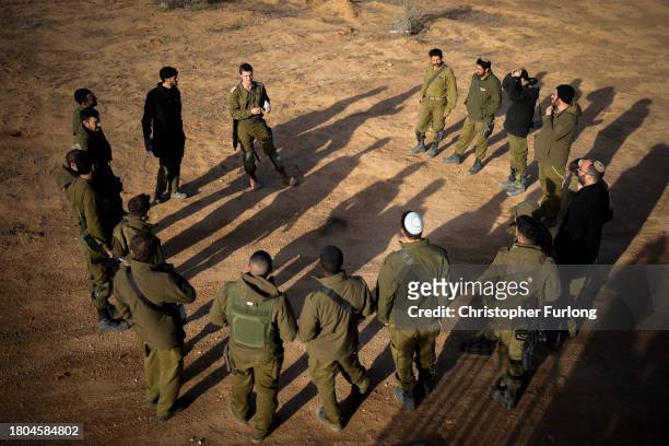 An Israeli platoon commander briefs his soldiers as they take part in a live firing tactical advance exercise, near the border, in readiness for...