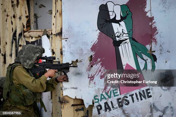 Save Palestine' sign adorns a wall as Israeli infantry soldiers take part in a live firing tactical advance exercise near the border in readiness for...