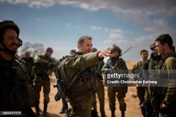IAn Israeli platoon commander briefs his soldiers as they take part in a live firing tactical advance exercise, near the border, in readiness for...