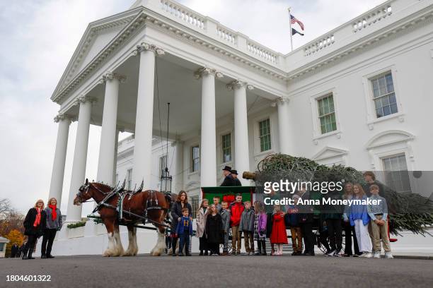 First lady Jill Biden and children of military families pose for a picture with the official 2023 White House Christmas Tree at the White House on...