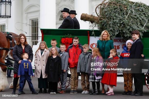 First lady Jill Biden and children of military families pose for a picture with the official 2023 White House Christmas Tree at the White House on...