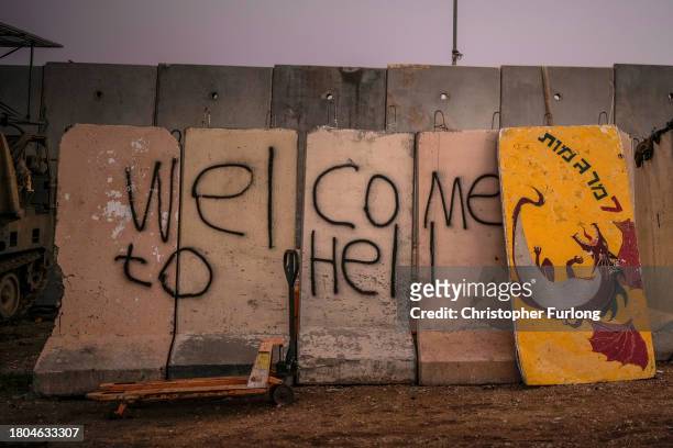 Graffiti saying 'Welcome To Hell' is adorned on the outside of a fortified forward observation post overlooking the border with Gaza on November 20,...
