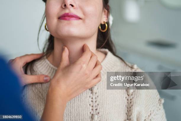 arzt, der die schilddrüse eines patienten überprüft - kehle stock-fotos und bilder