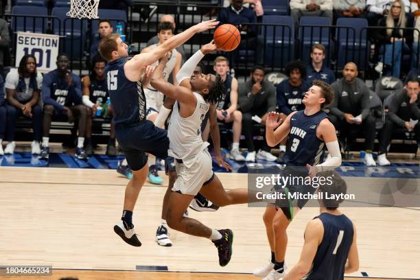 Darren Buchanan Jr. #3 of the George Washington Revolutionaries tries to get a shot off over Davide Poser of the New Hampshire Wildcats during a...