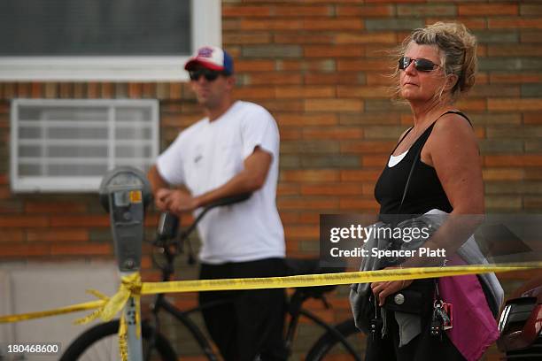 Residents look out at the scene of a massive fire that destroyed dozens of businesses along an iconic Jersey shore boardwalk on September 13, 2013 in...