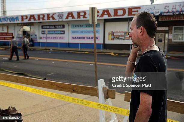 Daniel Shauger, manager at the heavily damaged Funtown Arcade, stands at the scene of a massive fire that destroyed dozens of businesses along an...
