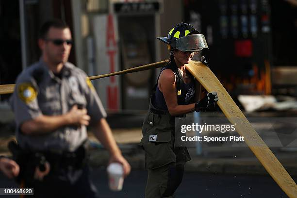 Firefighter pulls a hose at the scene of a massive fire that destroyed dozens of businesses along an iconic Jersey shore boardwalk on September 13,...